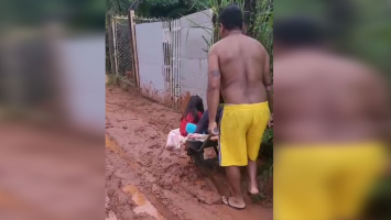VÍDEO: pai usa carriola para atravessar ruas com barro em dia de chuva e levar filhos ao ponto de ônibus para ir à escola